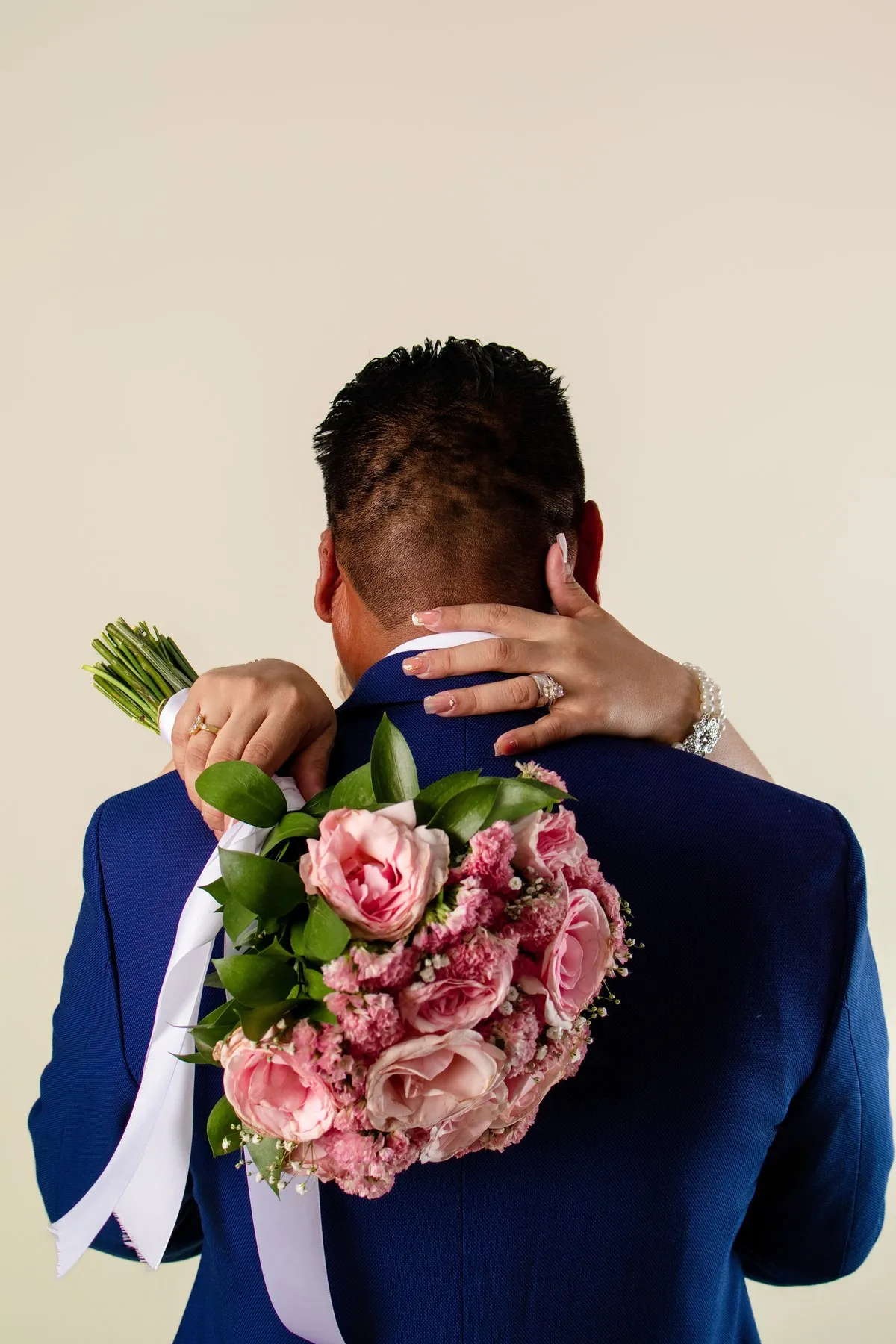 Los novios abrazados, el ramo sobre la espalda de él