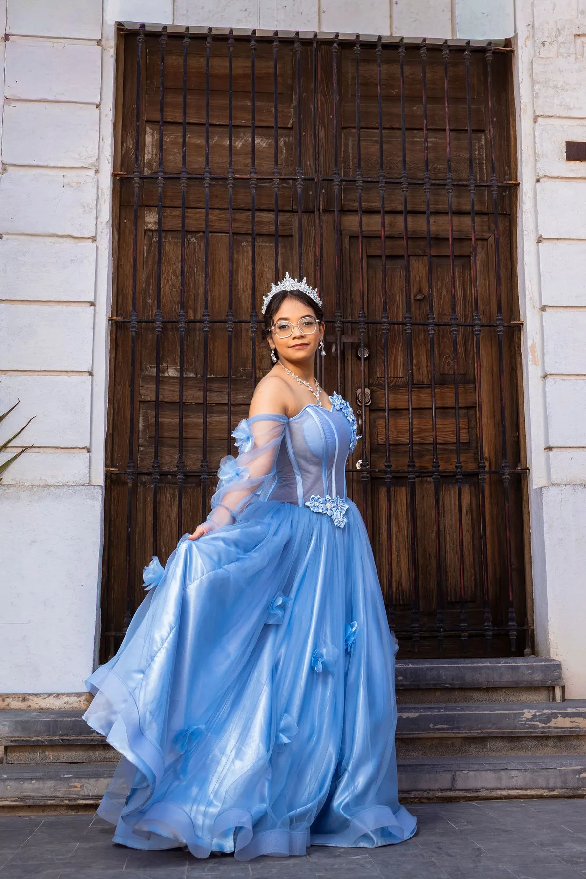 Quinceañera frente a un portón de madera
